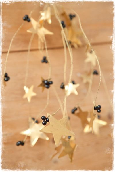 grote bos gouden sterretjes en zwarte kraaltjes aan goud draadijzer als kerstdecoratie