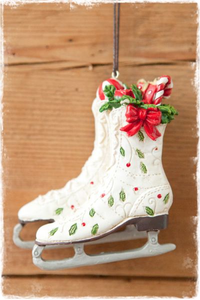 witte kunstschaatsjes met kerstversiering en cadeautjes in de schoen