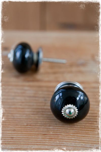 zwart porseleinen deurknopje met zilveren schroef en achterplaatje