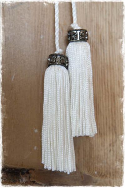 2 kleine witte tassels aan koord